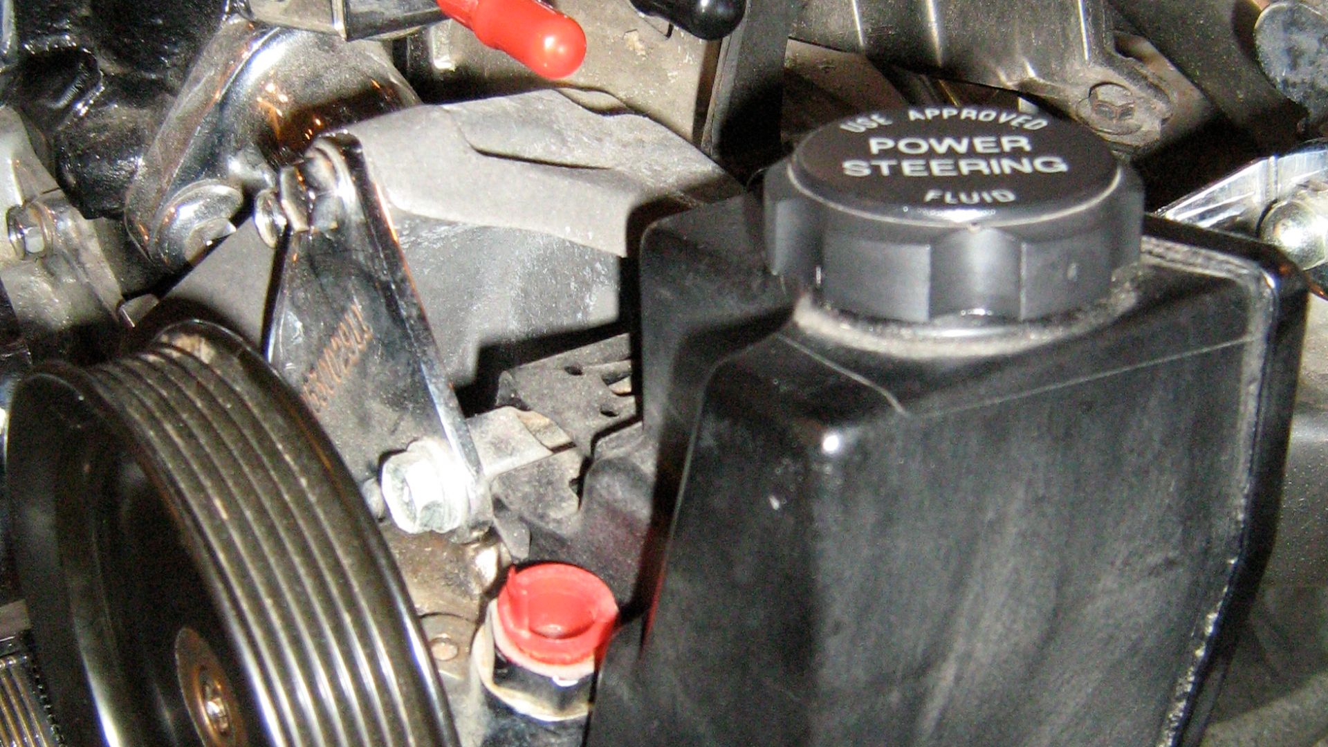 Jeep 2.5 liter 4-cylinder engine, chromed - close up of the power steering pump. This engine was developed by American Motors Corporation (AMC) and continued to be manufactured by Chrysler. All were built in Kenosha, Wisconsin.
