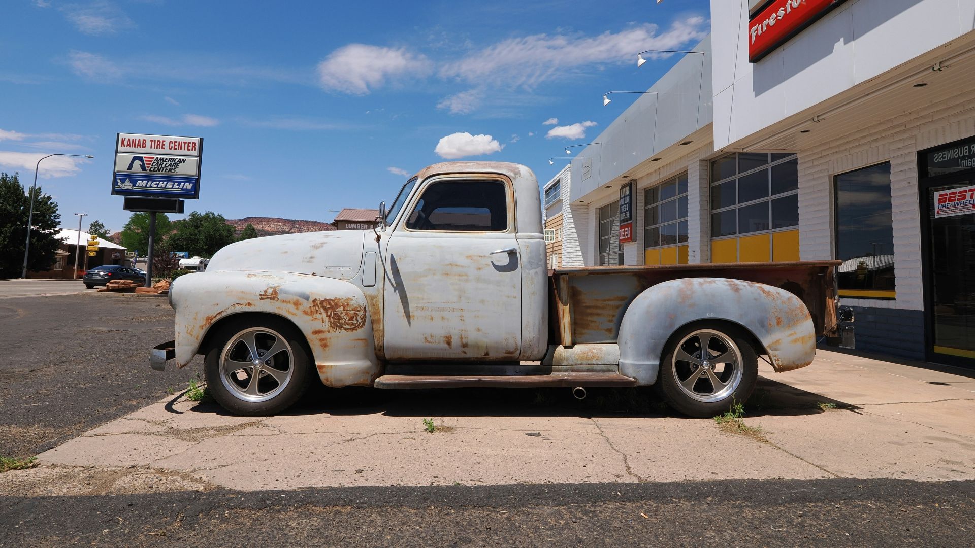 Old white pickup truck parked outside building