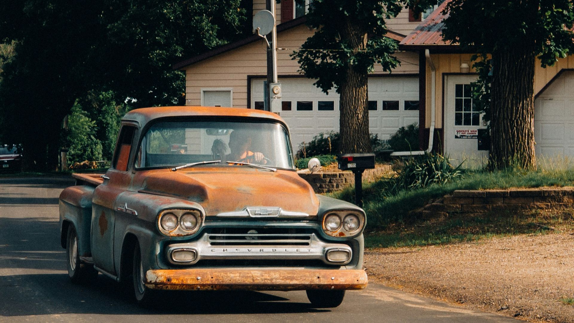 Vintage orange and blue pickup truck on a rural road