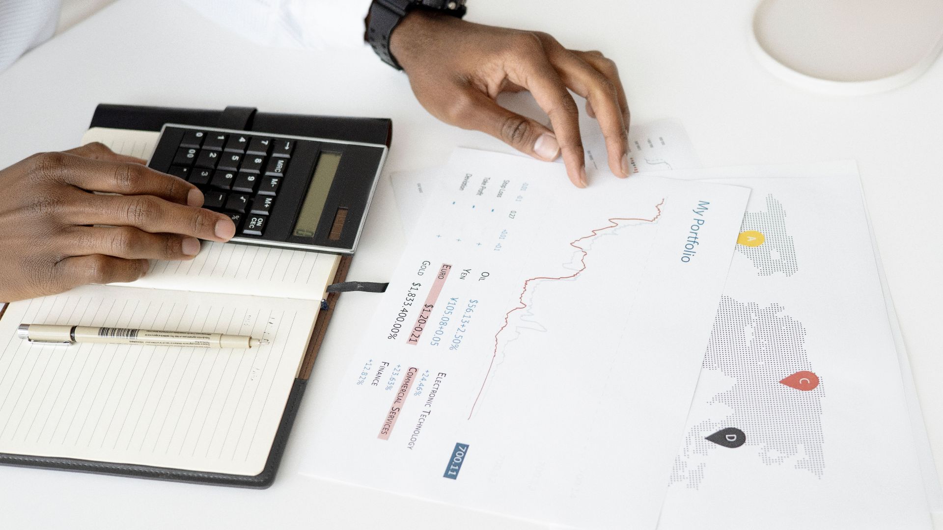 Overhead view of a person analyzing financial documents using a calculator for investment planning.