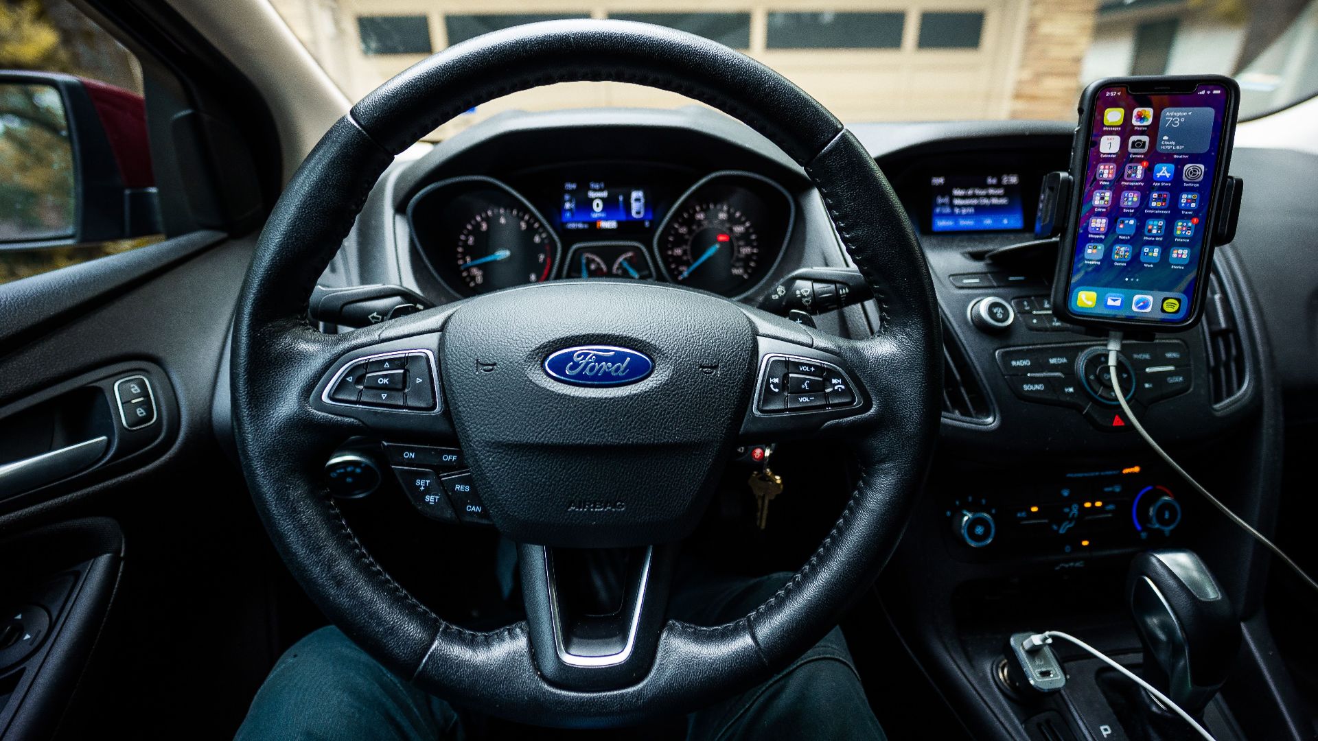 Interior view of a Ford car featuring a steering wheel, dashboard, and mobile device mount.