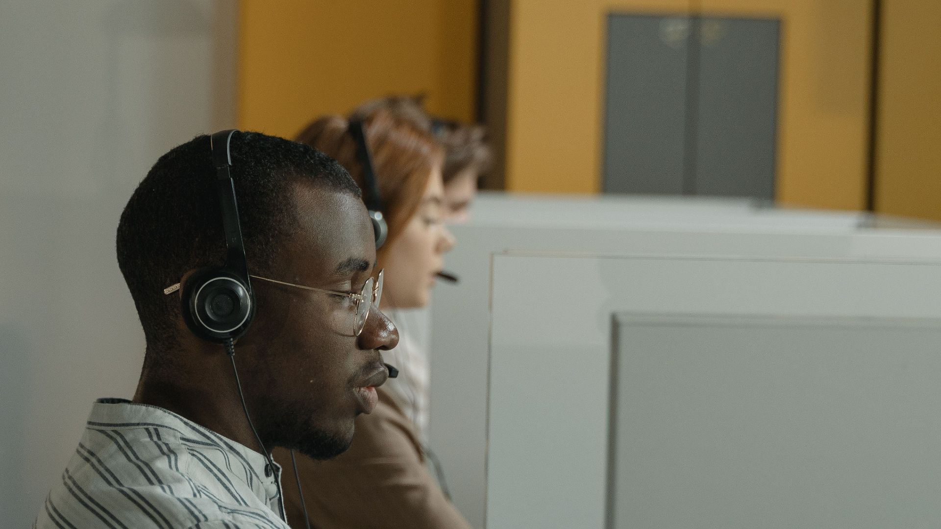 Professional call center agents working in a modern office environment, emphasizing teamwork and customer support.
