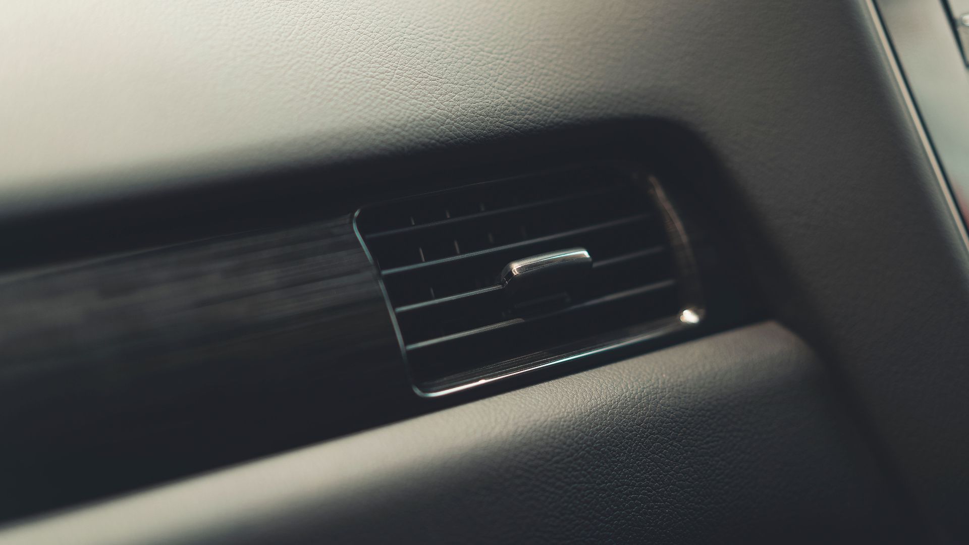 Detailed view of a car air vent system, showcasing interior design and texture.