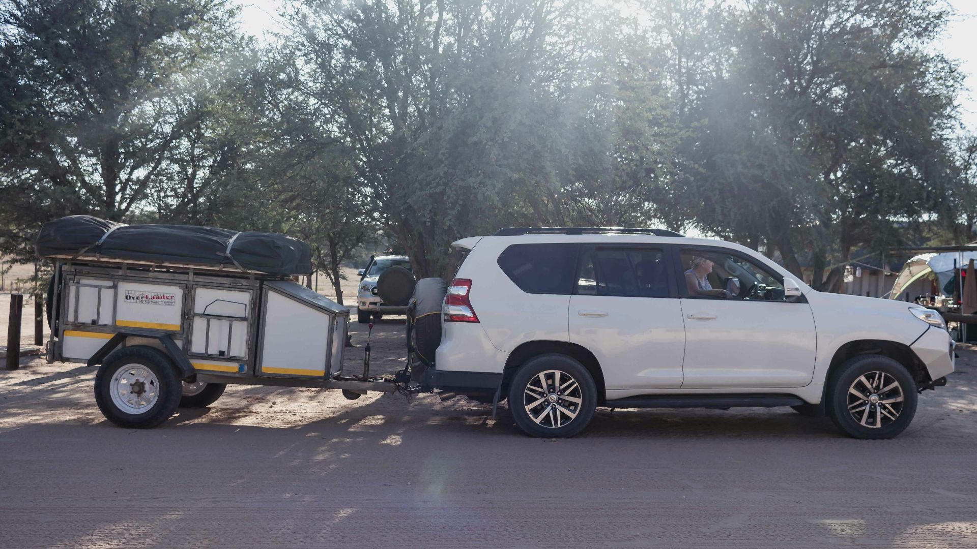 a white suv pulling a trailer with a boat on it