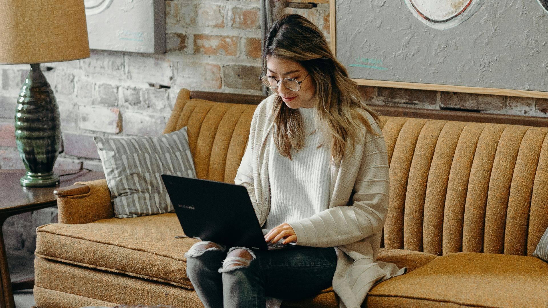woman using laptop while sitting on chair