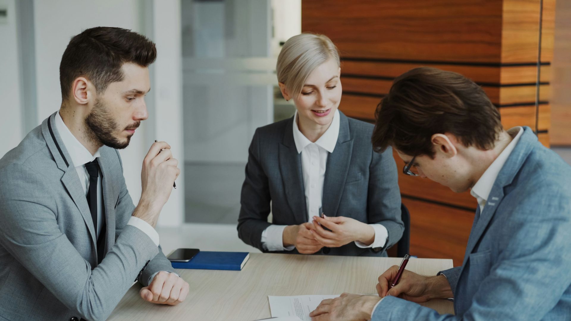 Business people signing a contract at a table