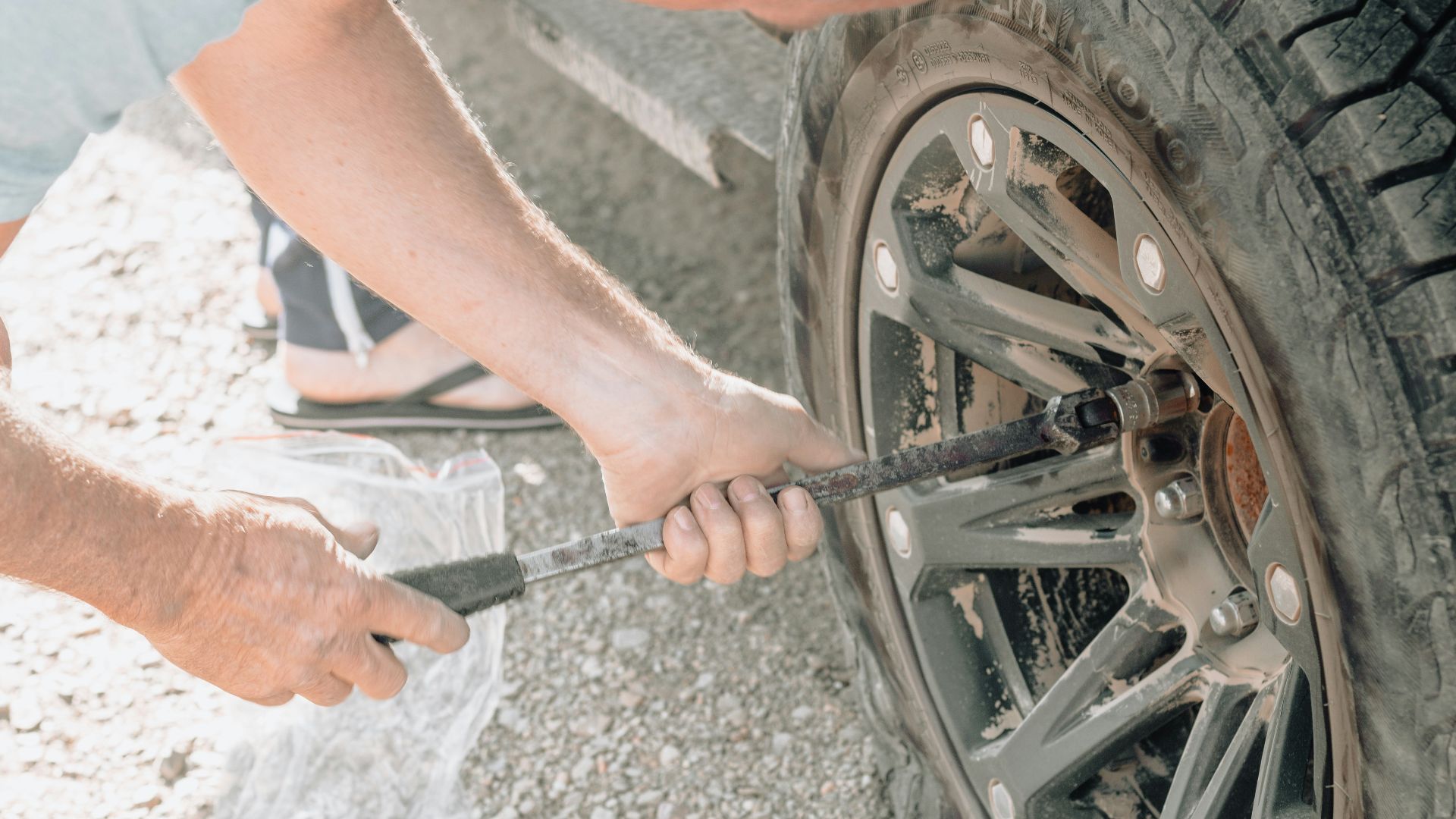 a man working on a tire with a wrench