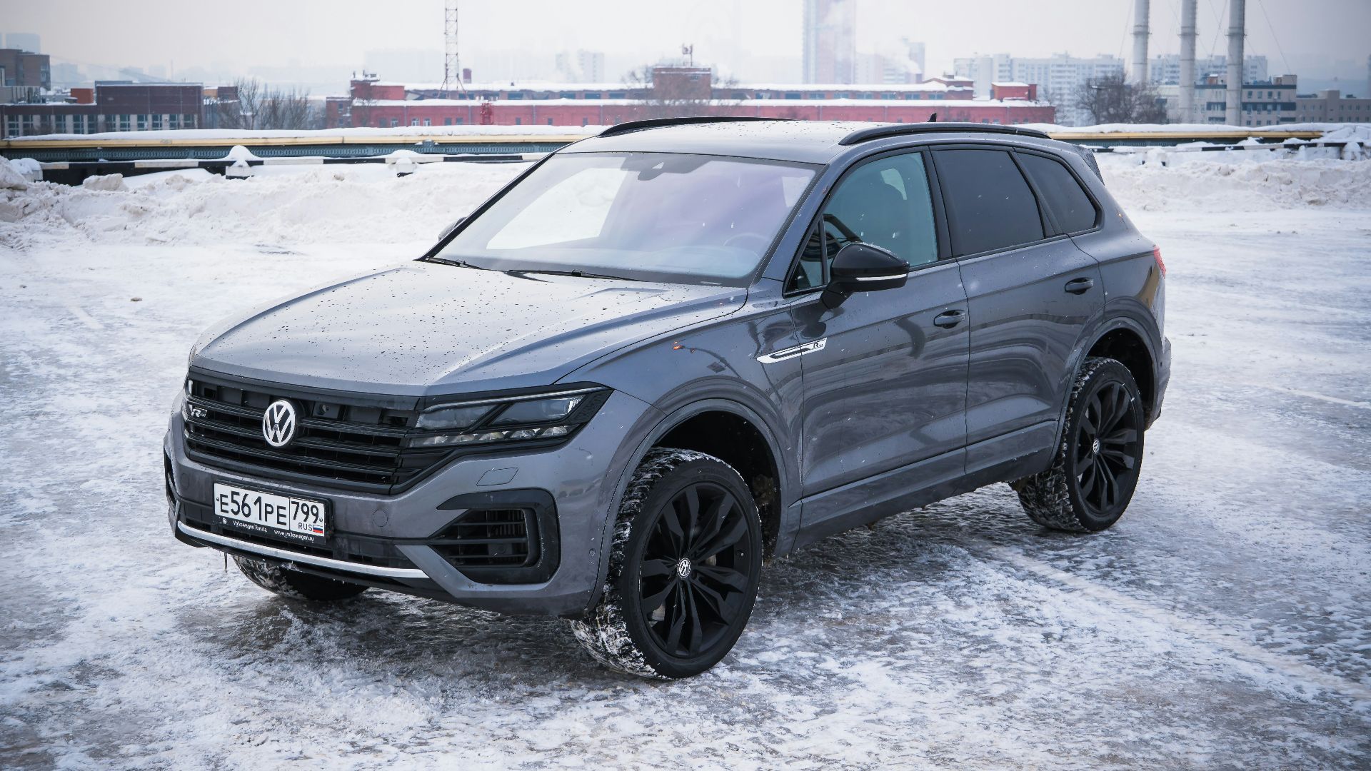 A gray volkswagen touareg parked on a snowy surface