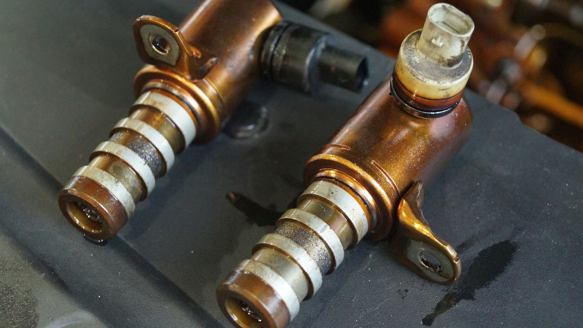 Two used engine solenoids with copper and silver parts