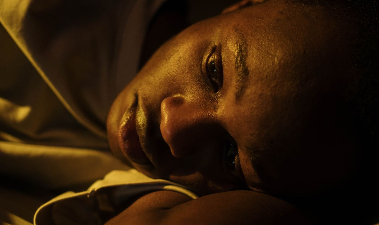 A young man lying awake in bed