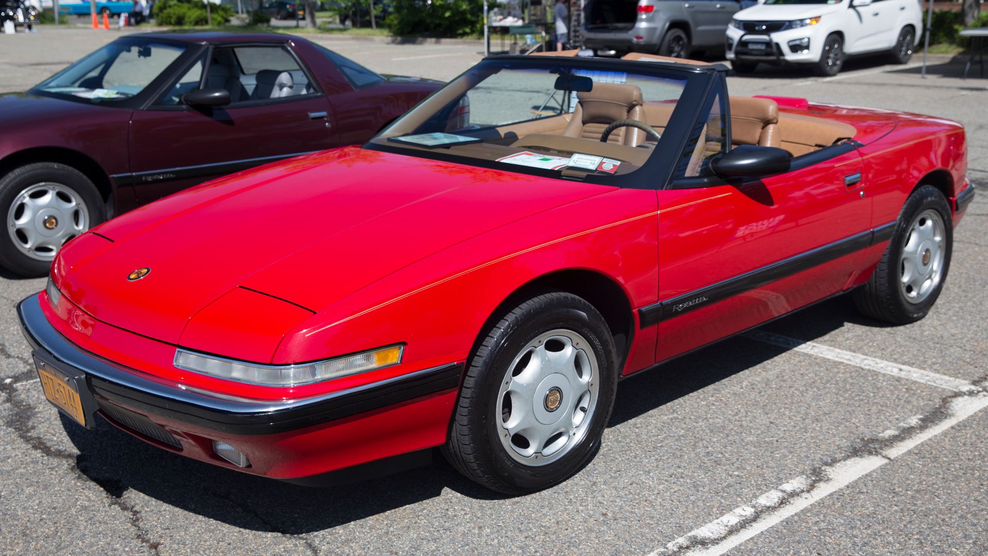 A 1991 Buick Reatta Convertible in Red with Saddle interior. 1991 was the only year for these 16-inch wheels, when a mere 305 convertibles were built. This is the 5024th Reatta overall and was delivered new to a Jablonski in New York in May 1991.