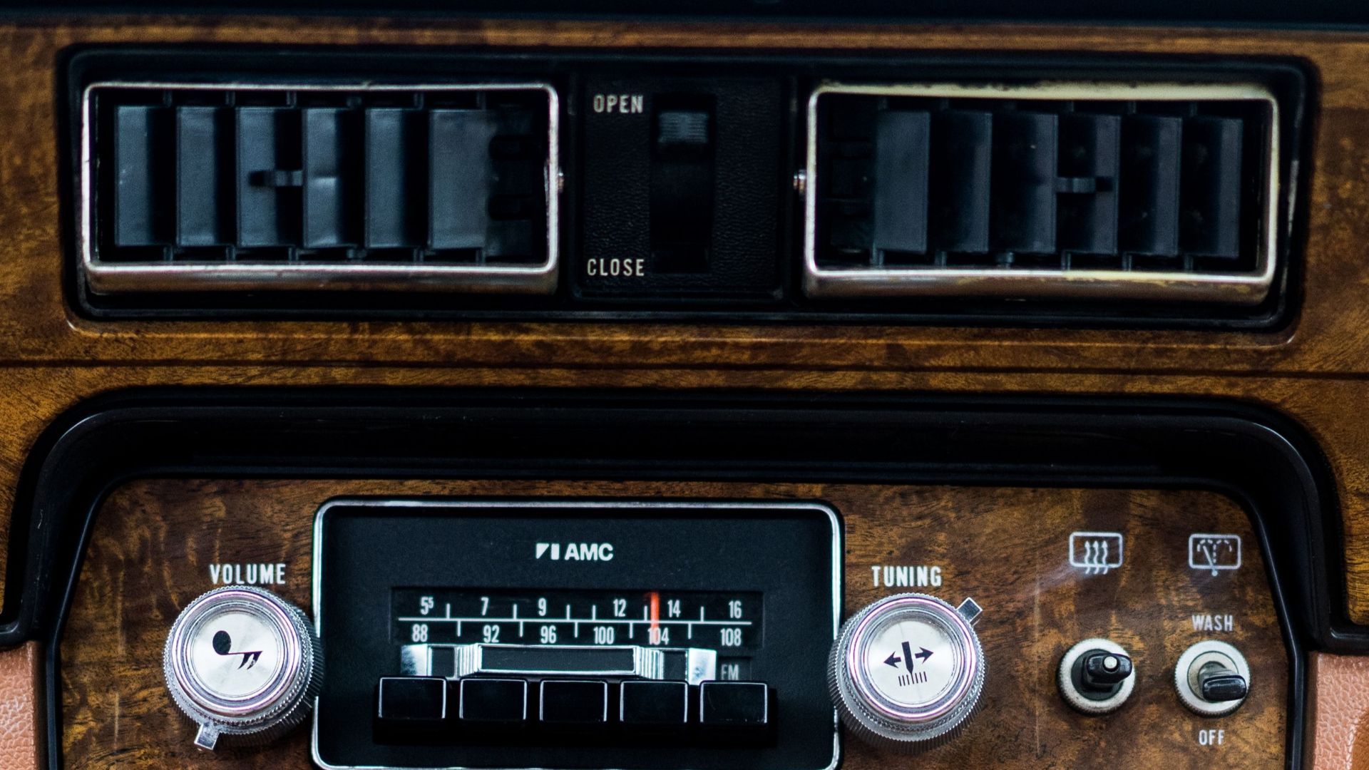 Old fashioned control dashboard with retro buttons and radio in aged brown automobile