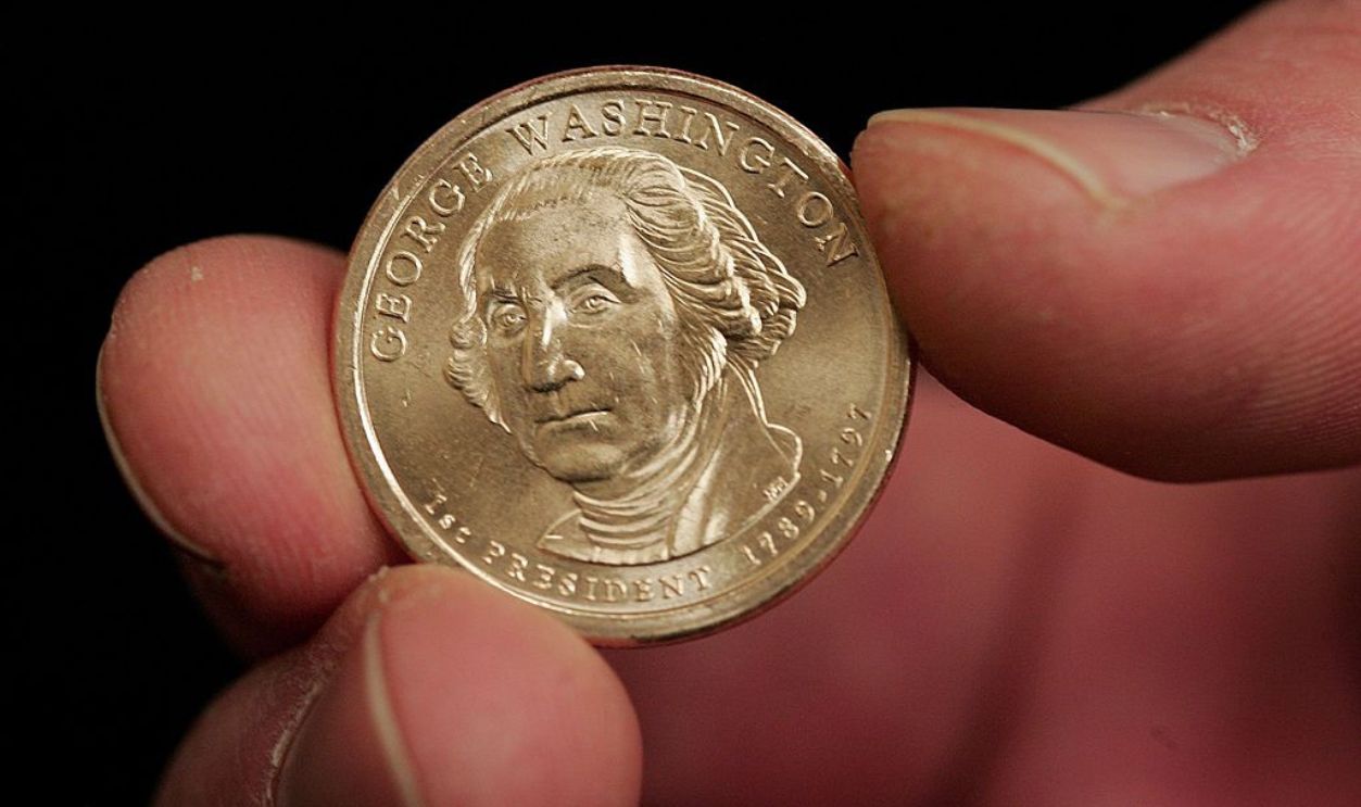 CHICAGO - JANUARY 24: A person holds a new coin as The United States Mint showcases the new Presidential series $1 coins, featuring the Statue of Liberty on the reverse, on January 24, 2007 in Chicago, Illinois. Four of the coins will be released each year featuring a different president. The first coin featuring George Washington goes into circulation February 15. 