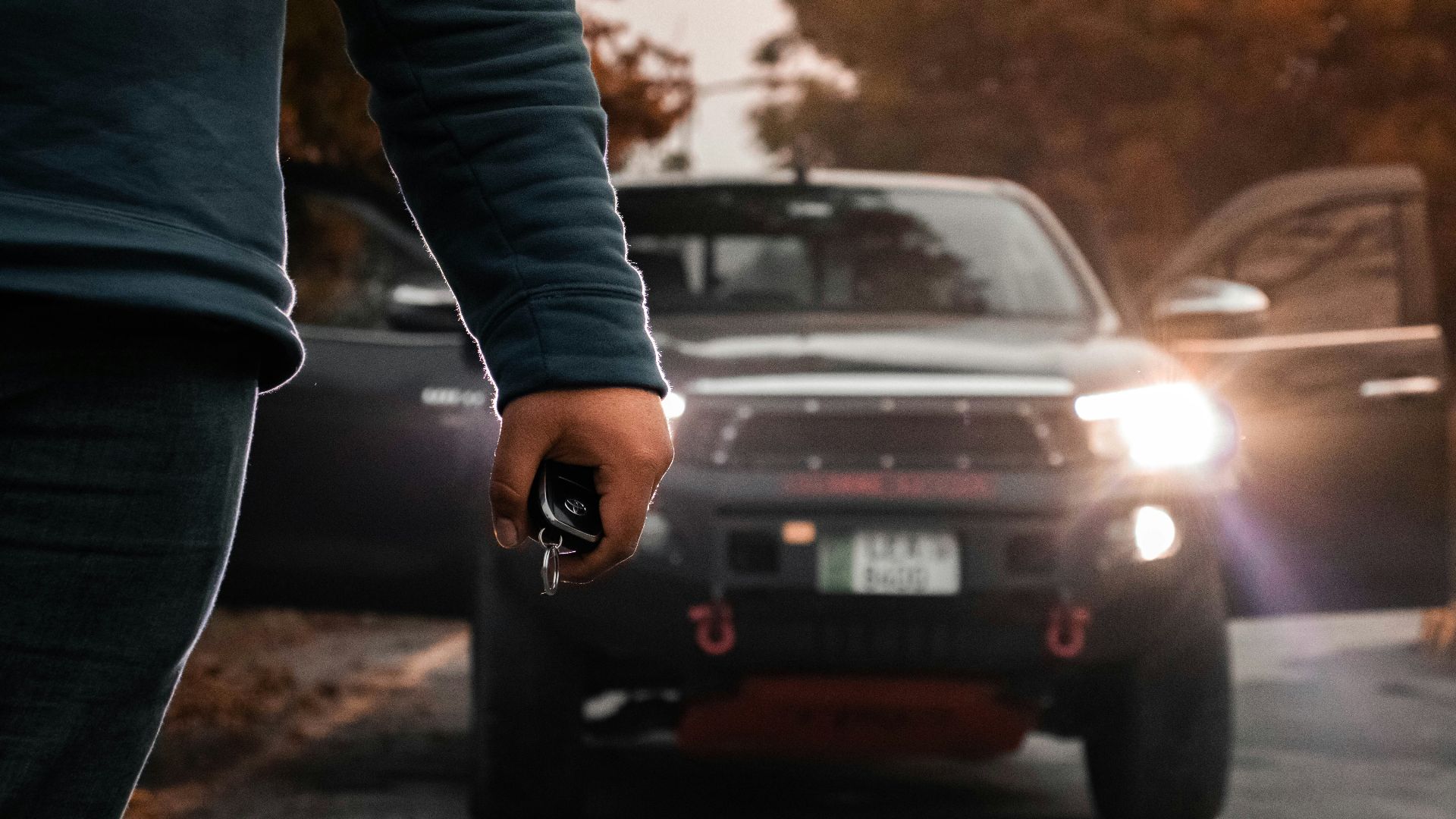 a man holding a gun in front of a car