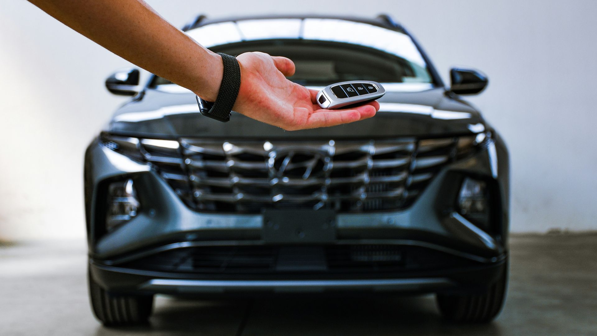person in black bracelet holding black car