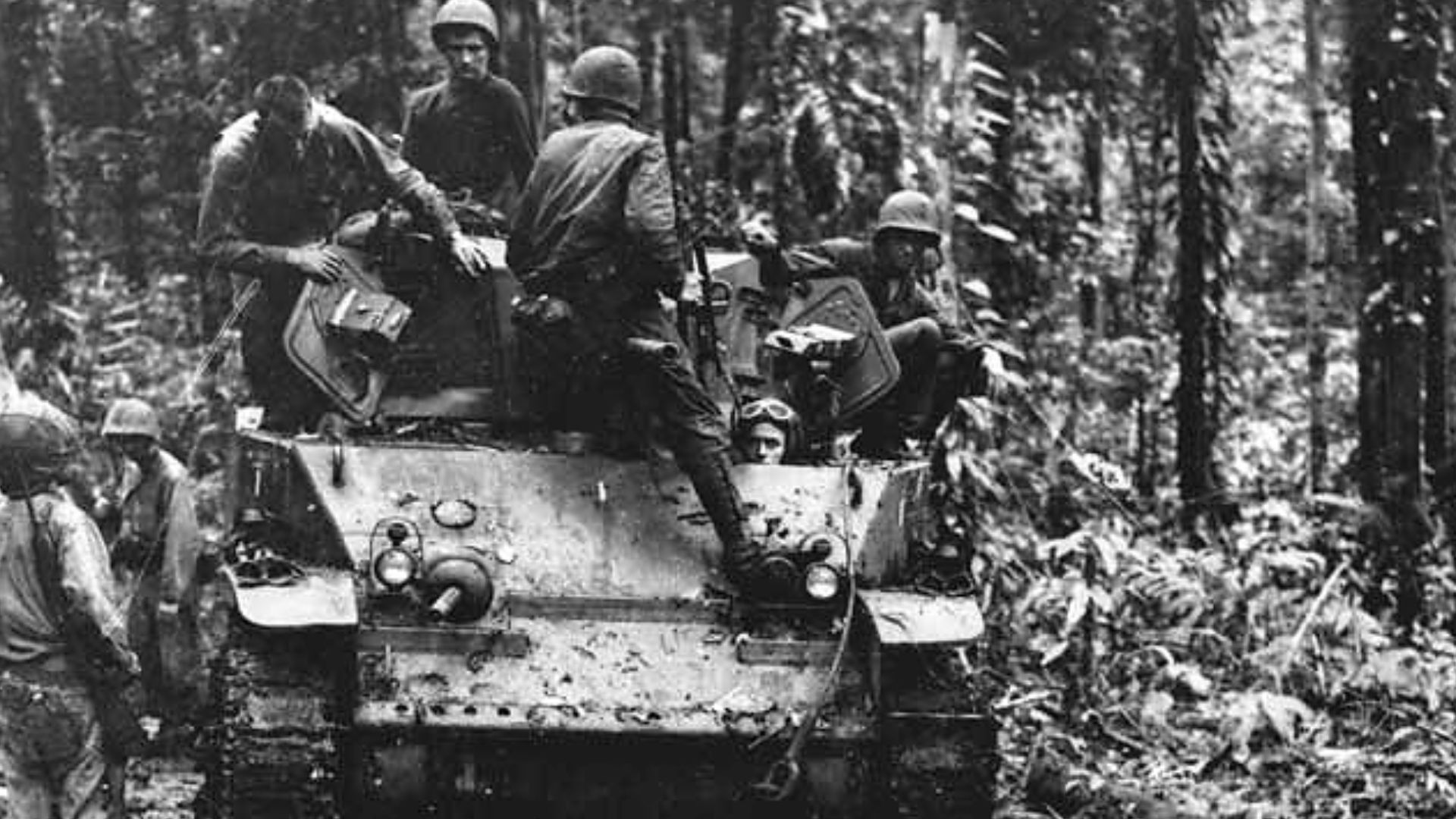 After a battle between the Marines and Japanese, a tank moves in to see the results on Cape Gloucester. In this same hollow a very bloody battle raged for four days. The tank is Light Tank M5/M5A1 aka Stuart.