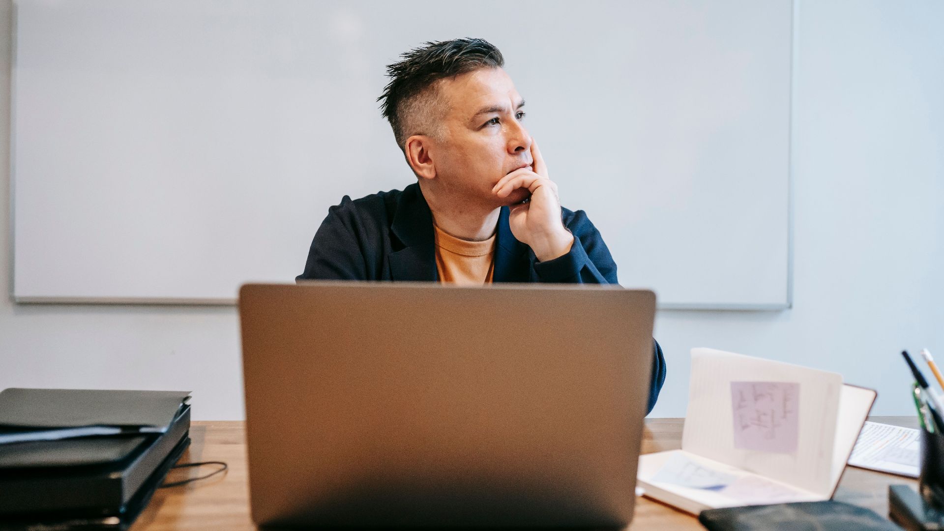 Focused businessman in home office, pondering work thoughts. Perfect for remote work and telecommuting concepts.