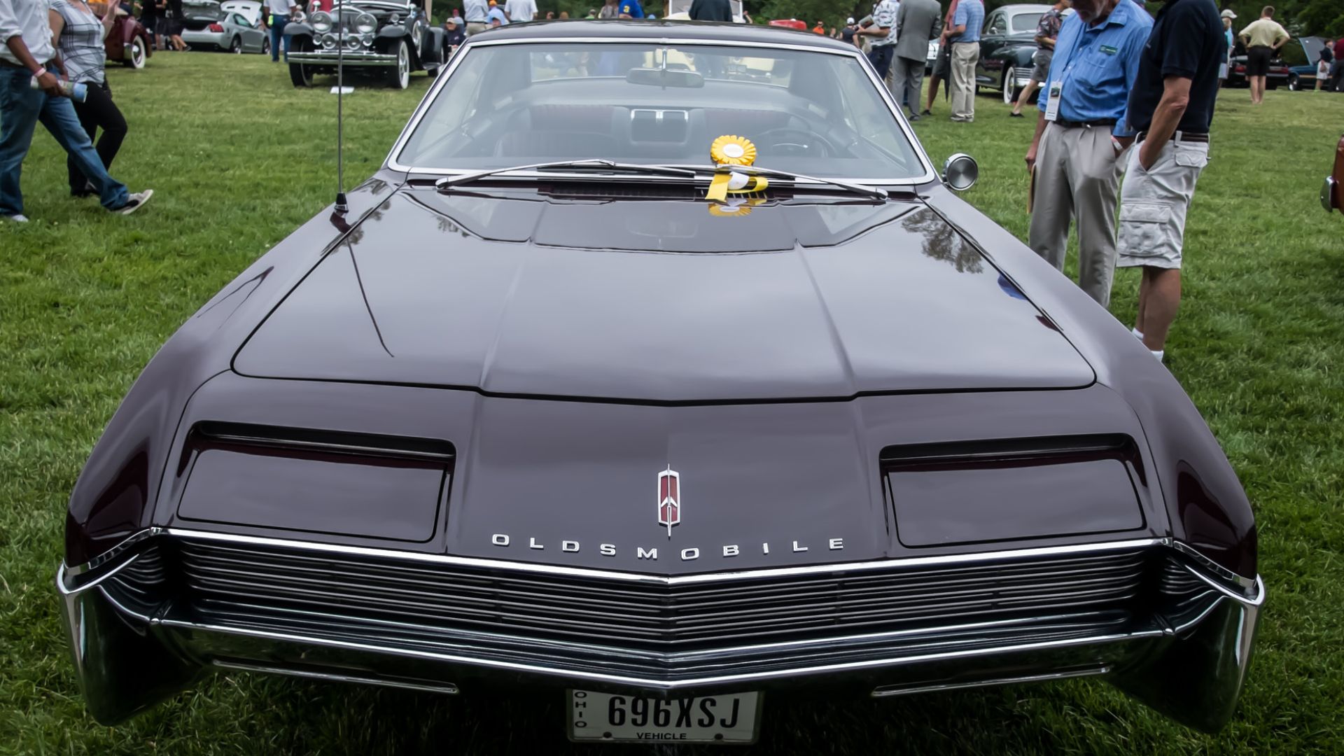 500px provided description: Show card text:  Chuck Loper, Richfield, OH * First front-wheel drive car built by GM * Only two owners since new - 36,000 miles * 425 cu. in, 385 hp V-8 engine * Innovative silent chain drive between engine and transmission * 