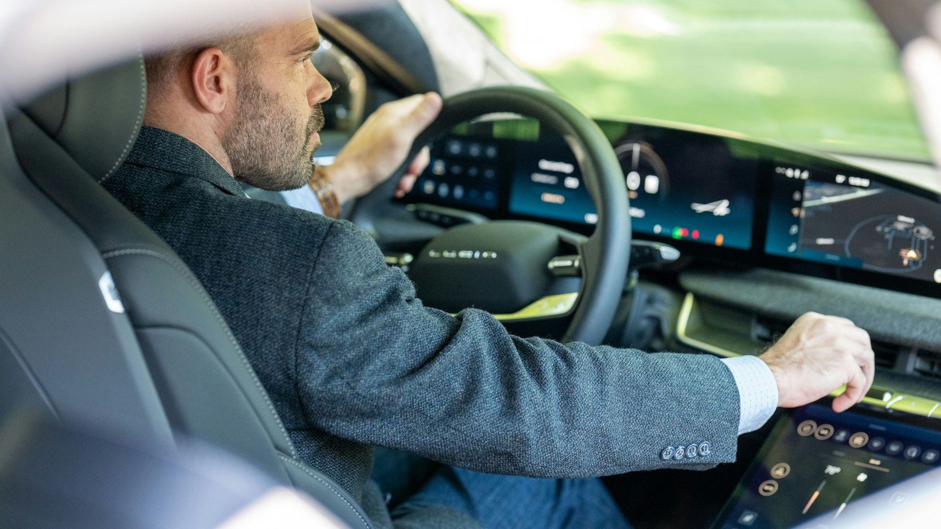 a man in a suit driving a car