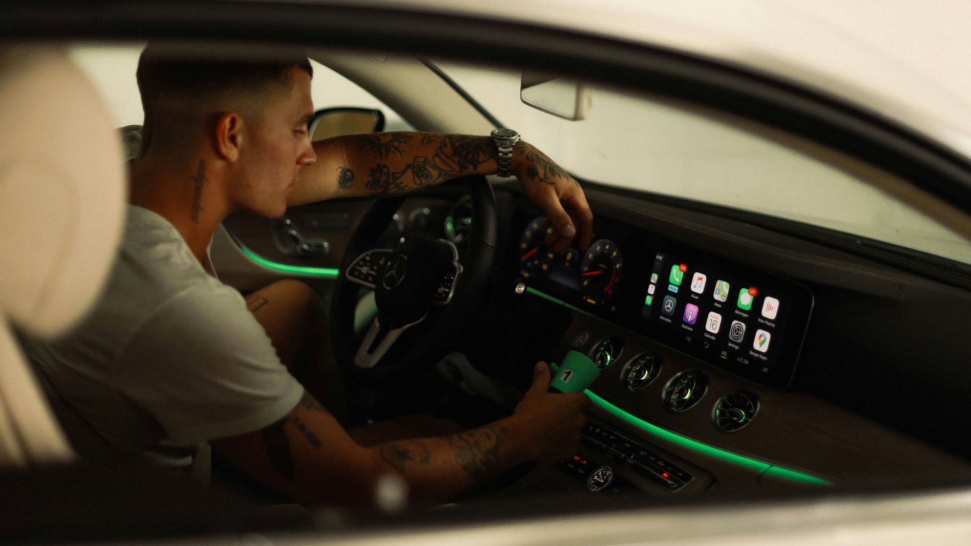 man in white polo shirt driving car