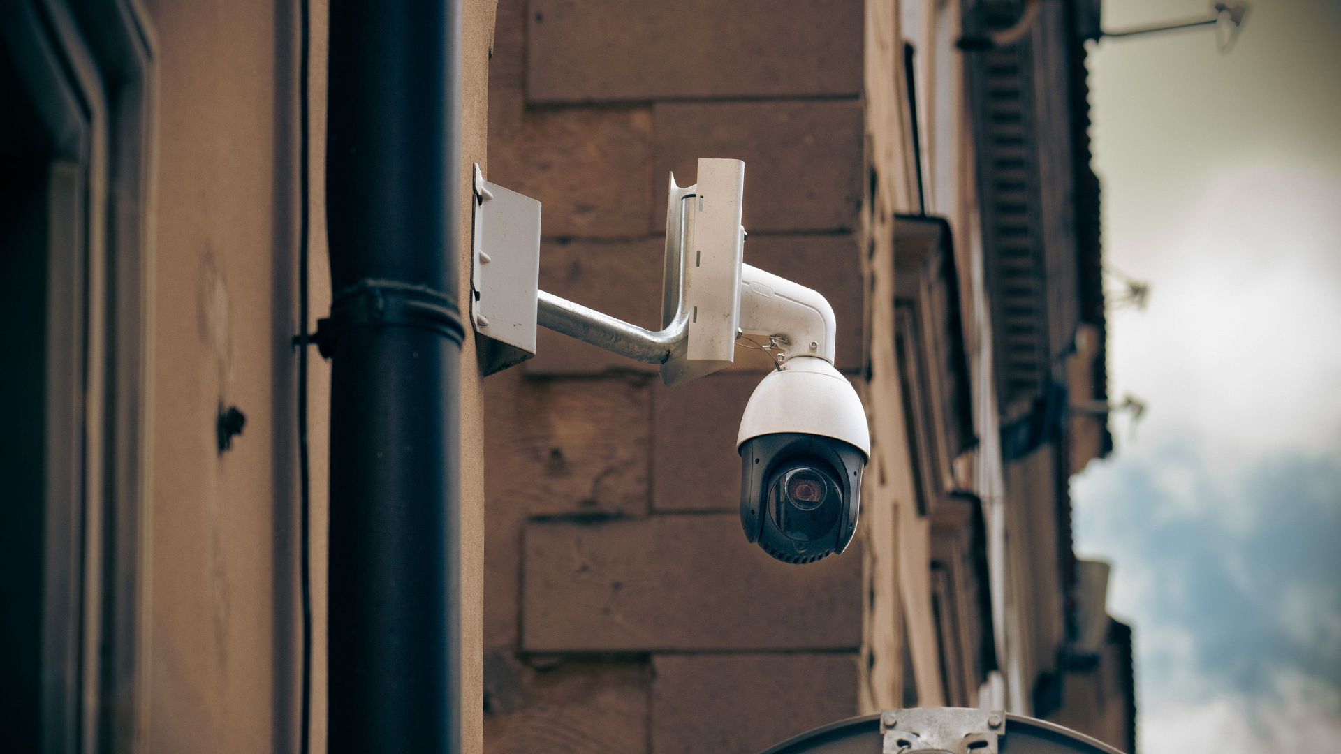 CCTV camera mounted on a building wall in an urban street setting, enhancing security.
