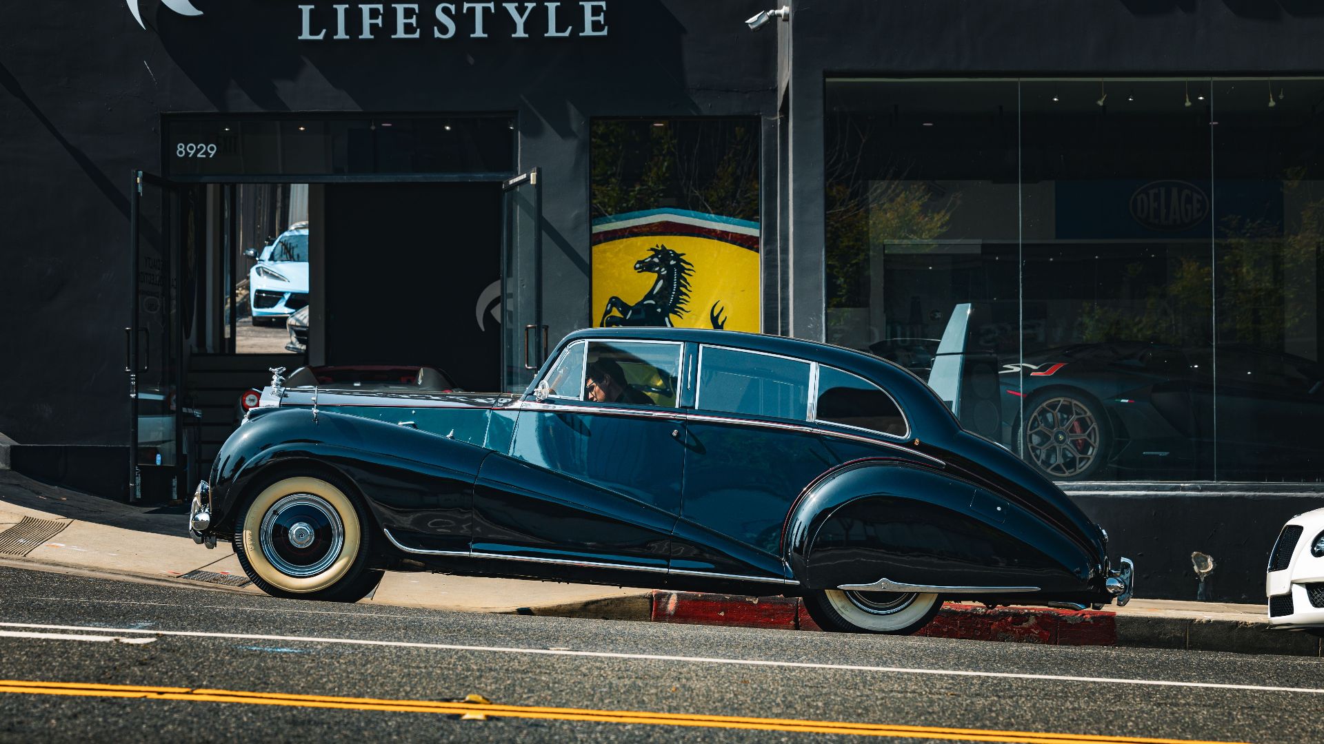 Vintage car parked outside a luxury showroom in Los Angeles, California.