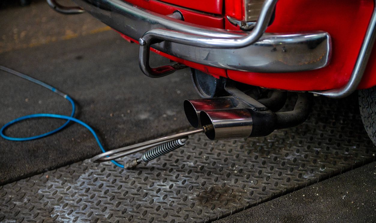 Exhaust emissions test on a classic car during vehicle inspection using an exhaust gas analyzer in a professional automotive workshop