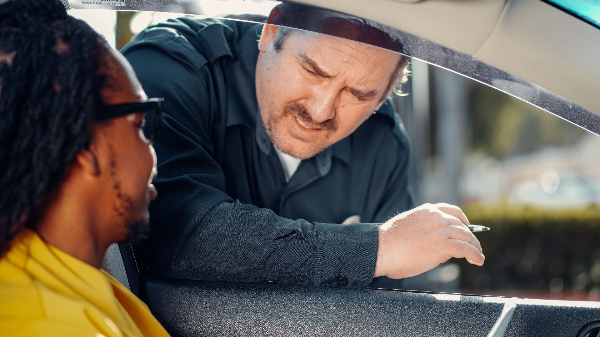 A police officer interacts with a driver through a car window, emphasizing law enforcement and public safety.
