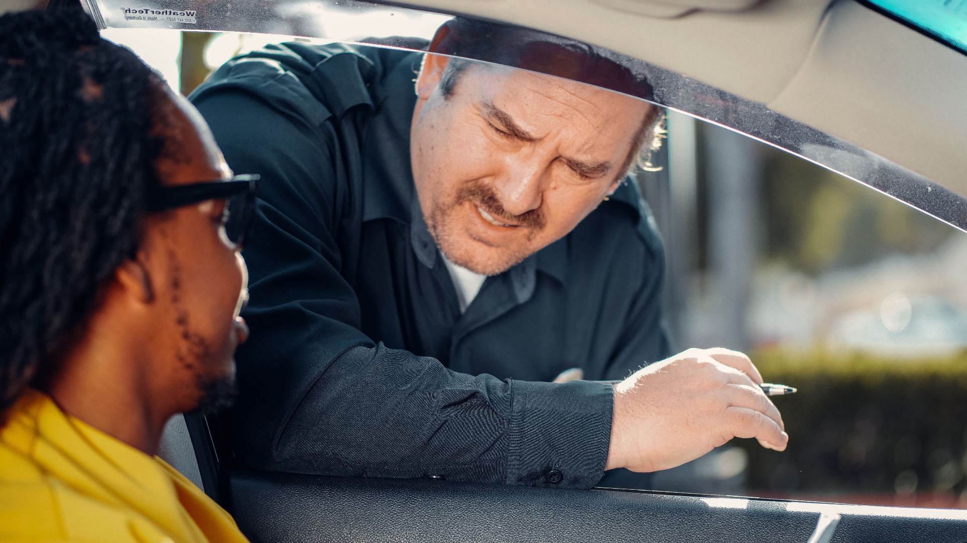 A police officer interacts with a driver through a car window, emphasizing law enforcement and public safety.
