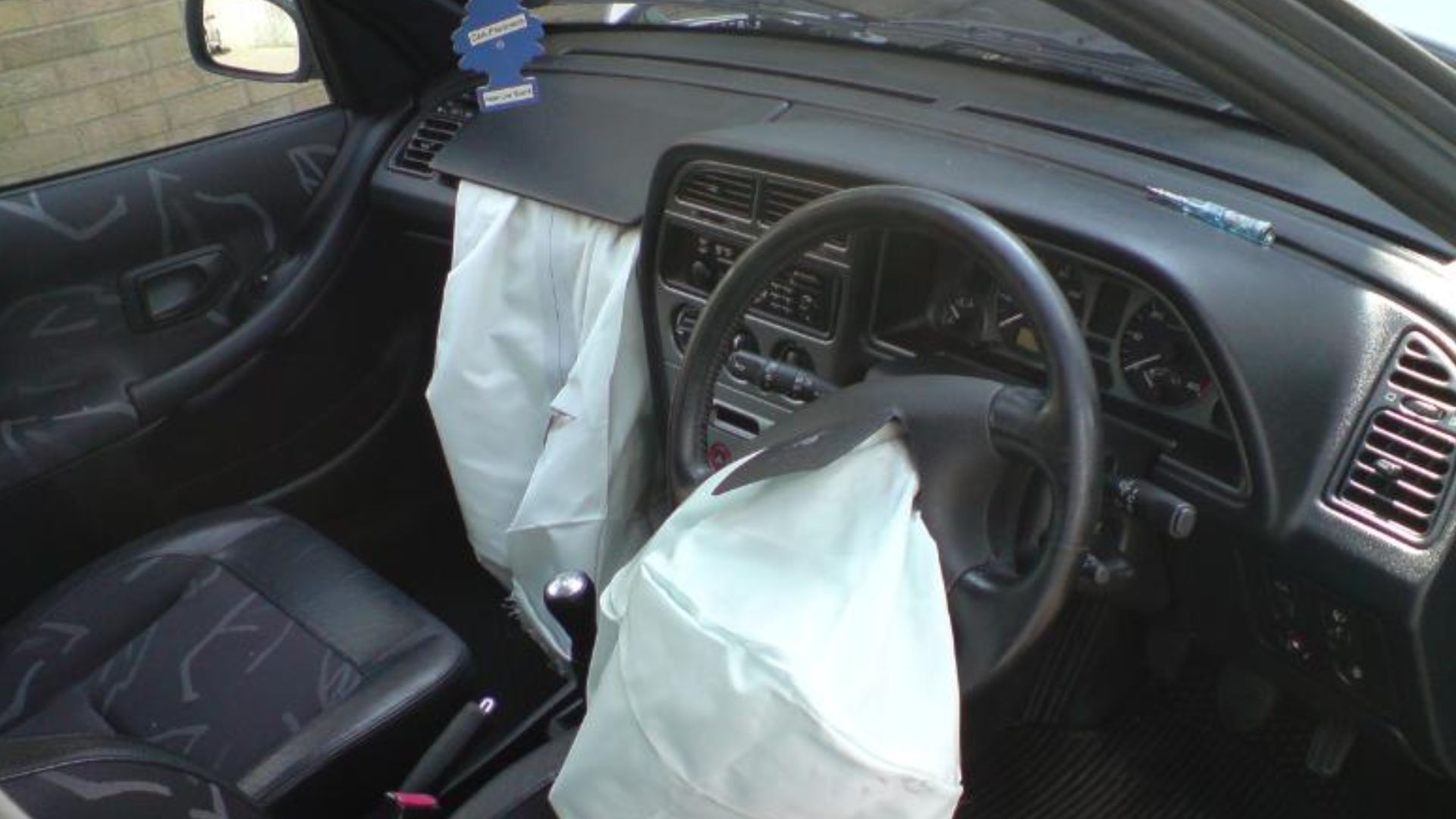 Interior photo of a Peugeot 306 with airbags deployed.