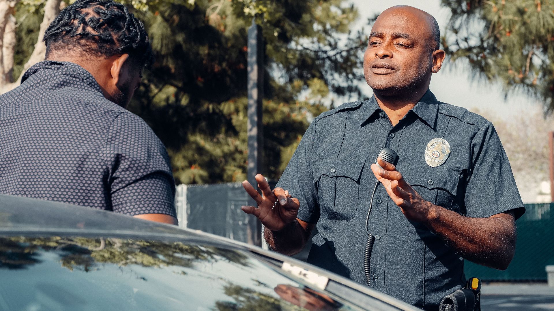 A police officer engages in conversation outdoors, reflecting community service and law enforcement.