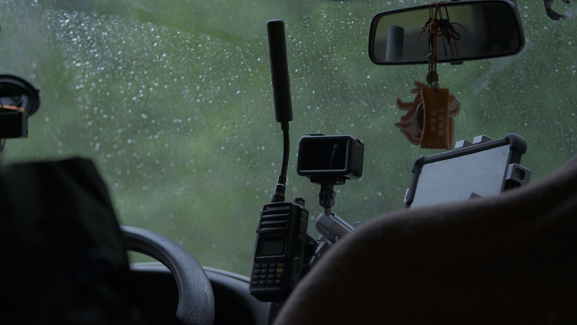 Car interior with rain on windshield and electronic devices