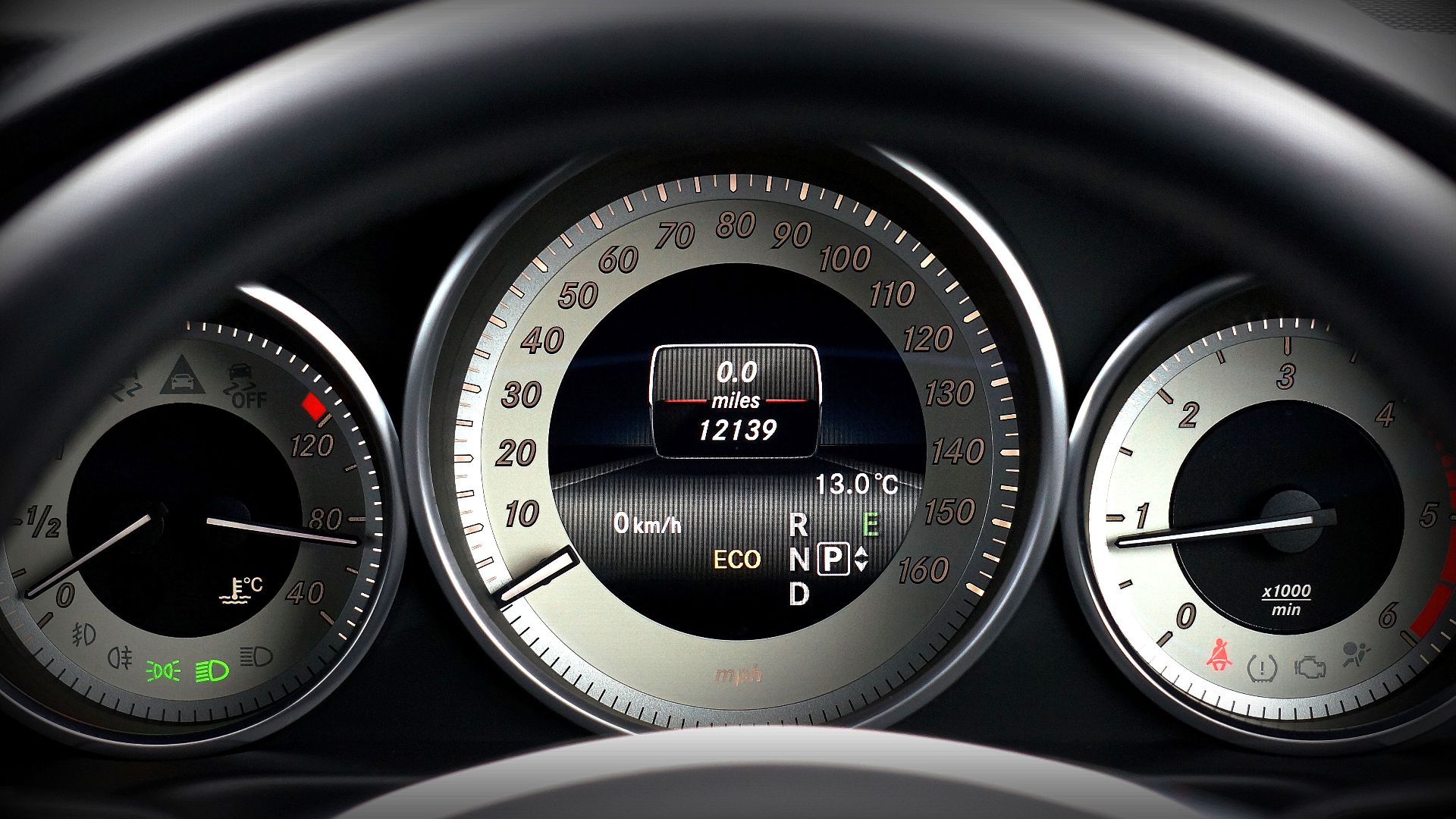 Close-up image of a car dashboard highlighting speedometer, odometer, and temperature gauge.
