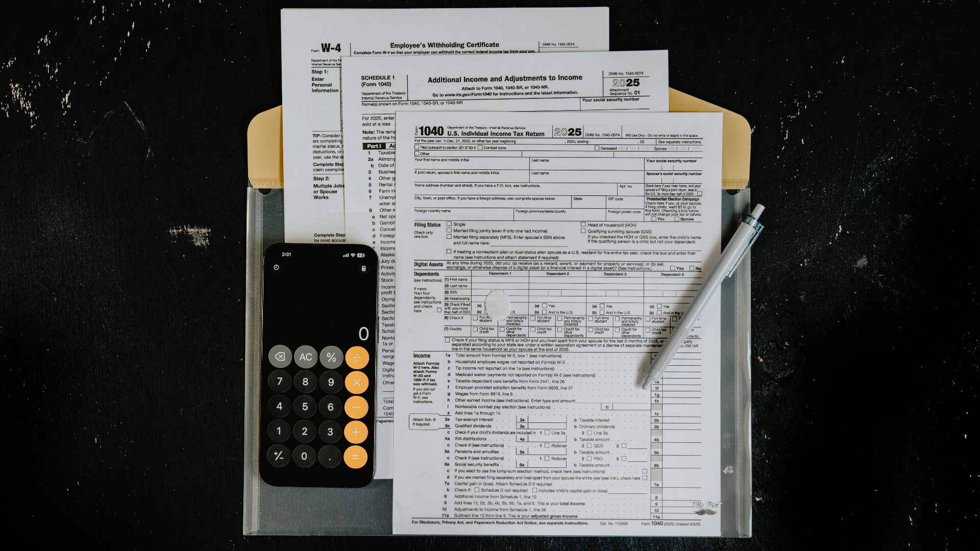 Tax forms with calculator and pen on dark surface