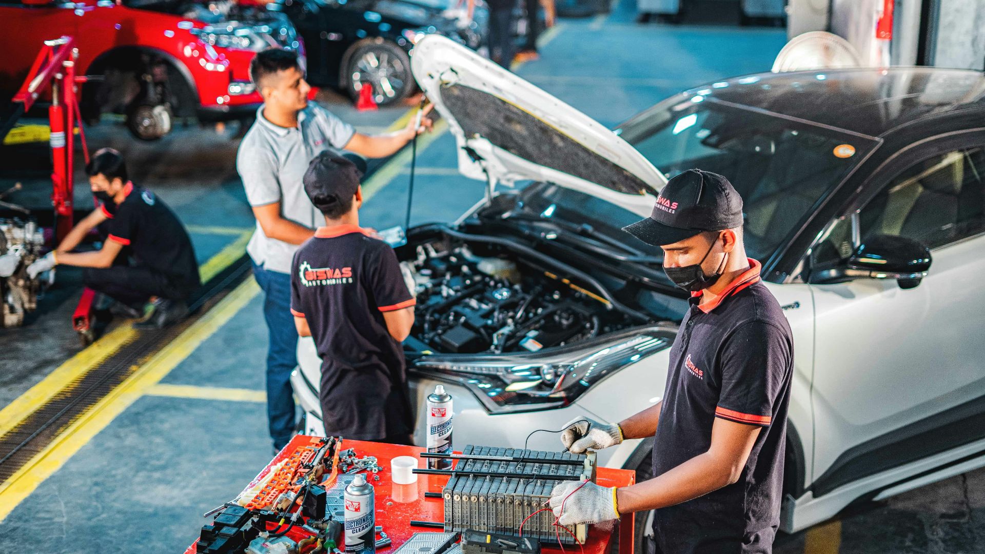 A group of men working on a car in a garage