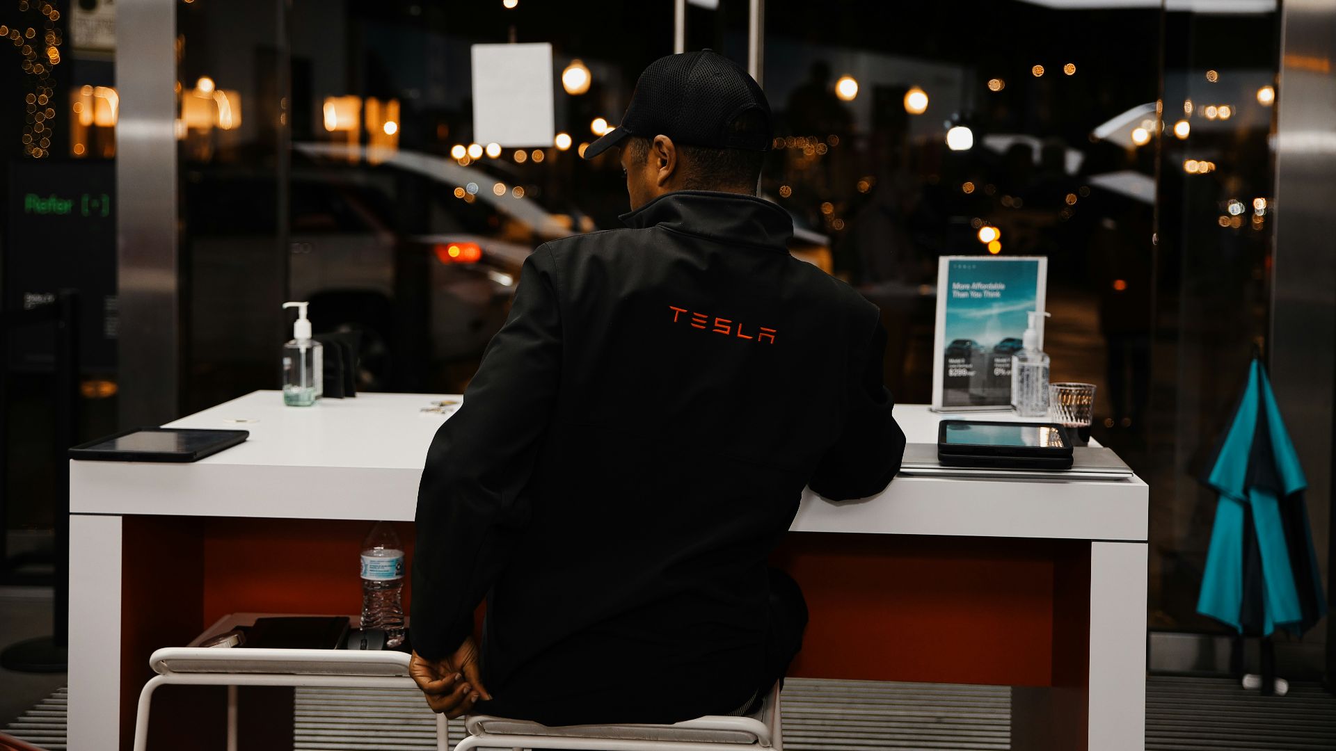 A man sitting at a desk in front of a laptop computer