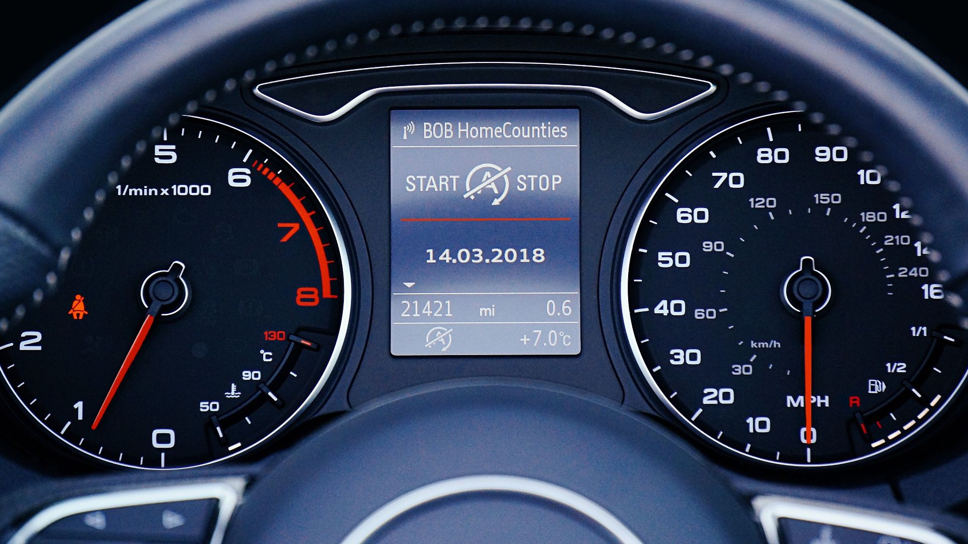 Close-up of a car dashboard displaying speedometer, tachometer, and digital display with mileage.