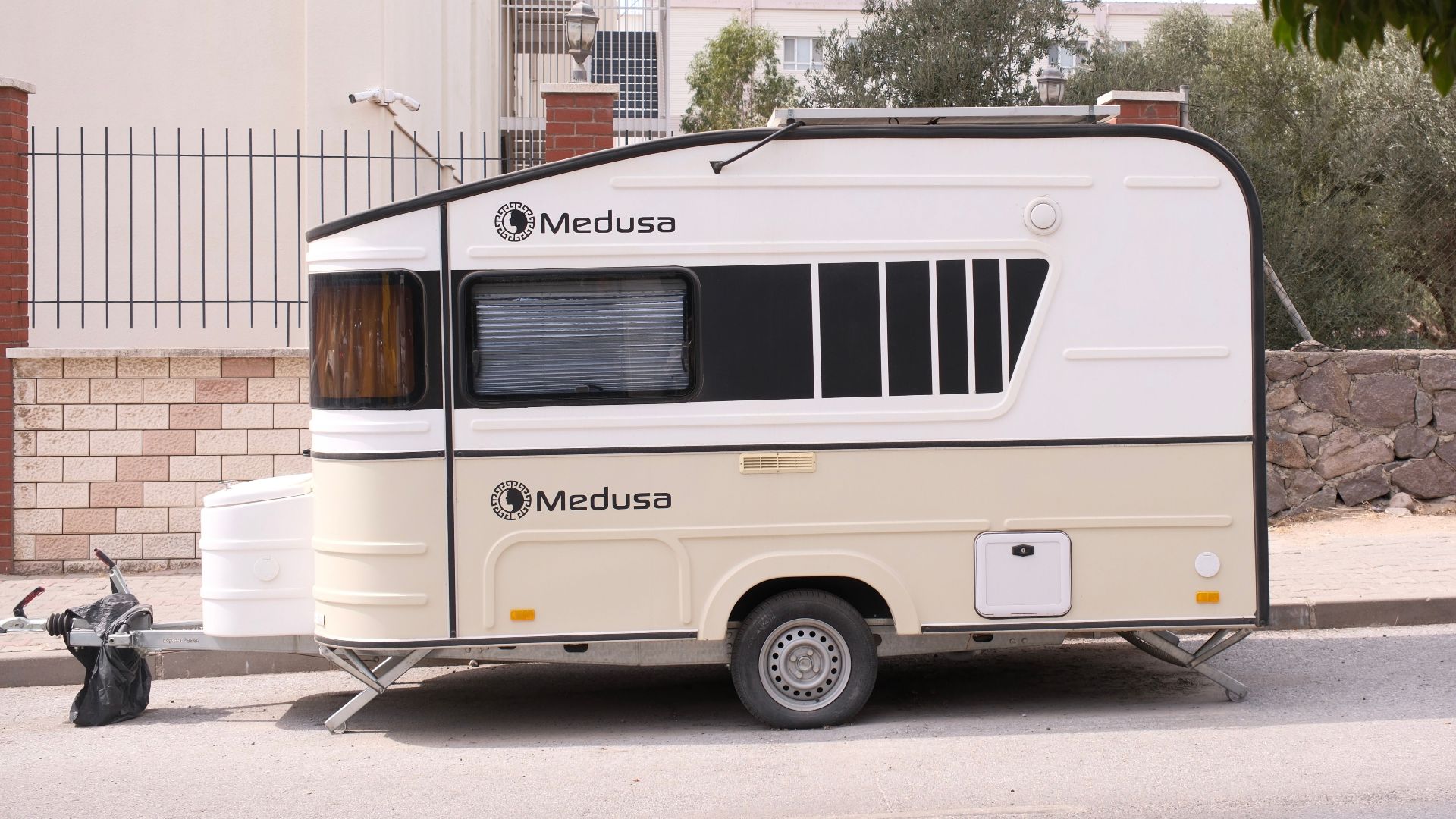 A Medusa caravan parked on a sunny street in İzmir, Türkiye, next to urban buildings.