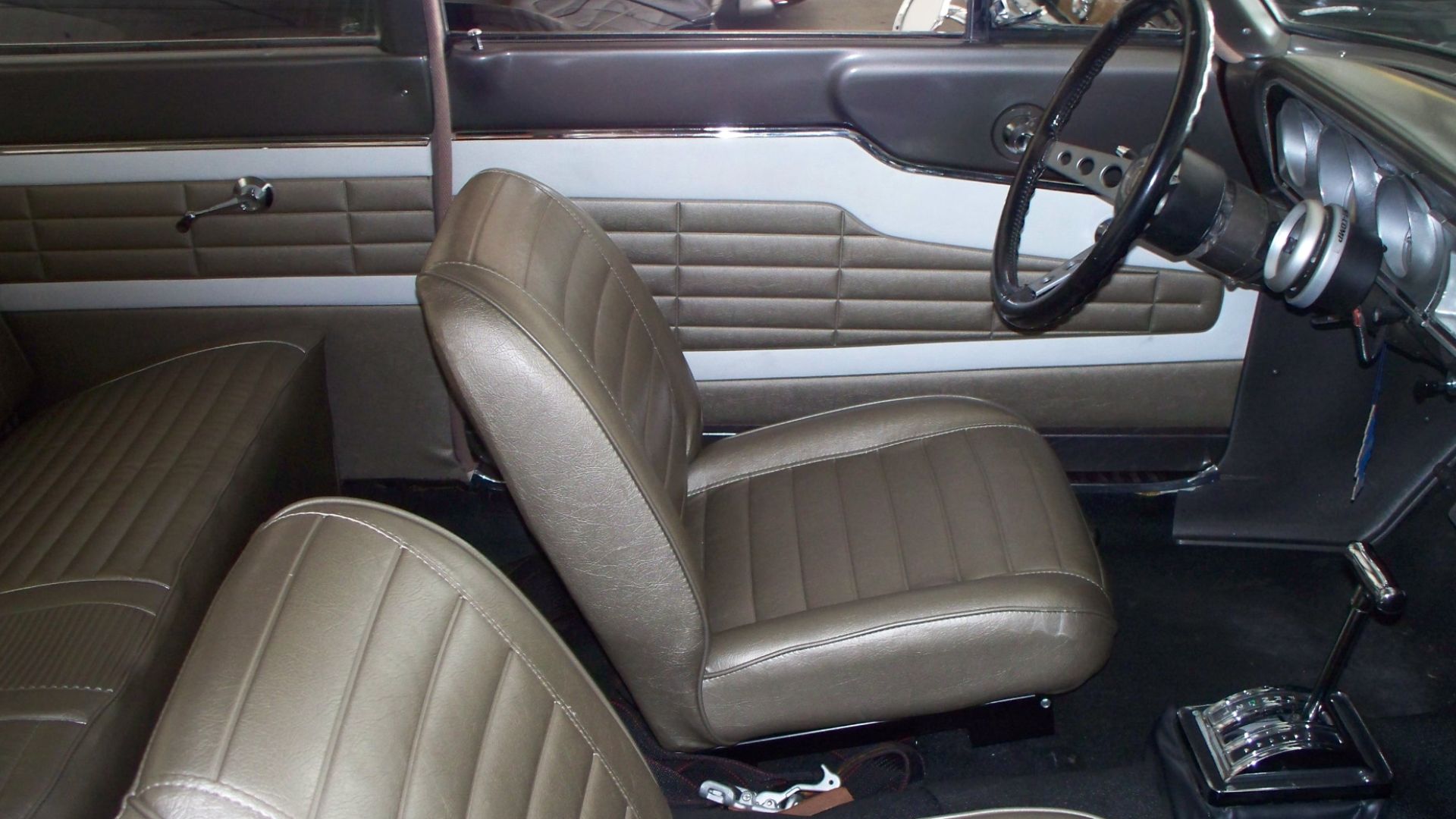 Interior of a modified, street-driven 1964 Ford Fairlane Thunderbolt factory experimental drag race car.  The armrests and radio were deleted to save weight; additional weight savings were found in the use of Ford Econoline van bucket seats.  Steering whe