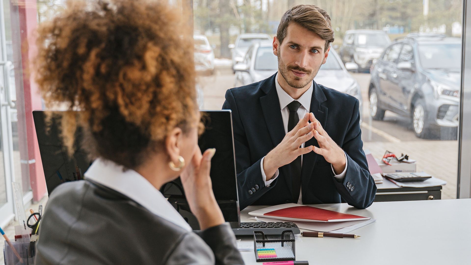 Business professionals engaged in conversation at a modern office desk, discussing ideas and strategies.