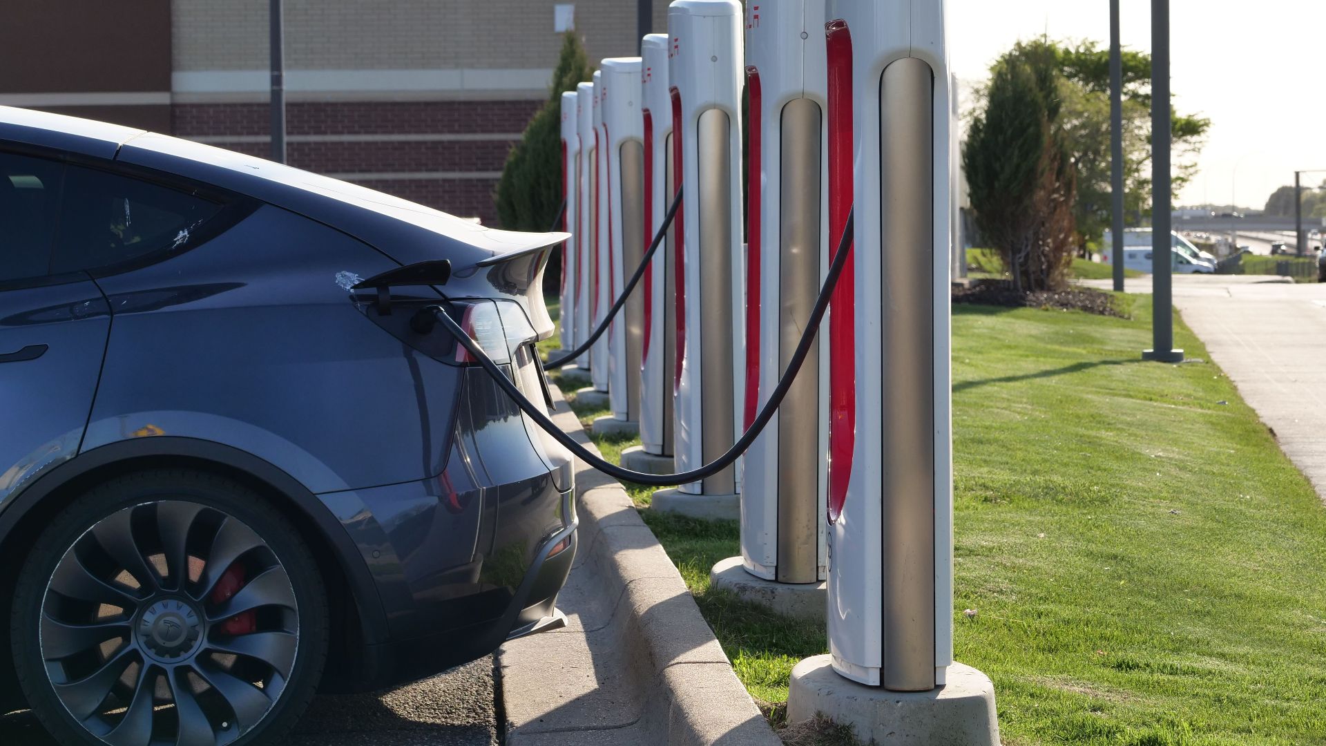 Electric car plugged into a row of charging stations, showcasing modern EV infrastructure.