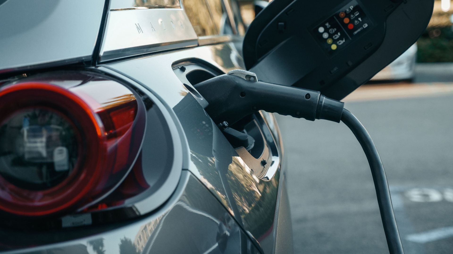 Close-up of an electric vehicle being charged, highlighting modern clean energy technology.