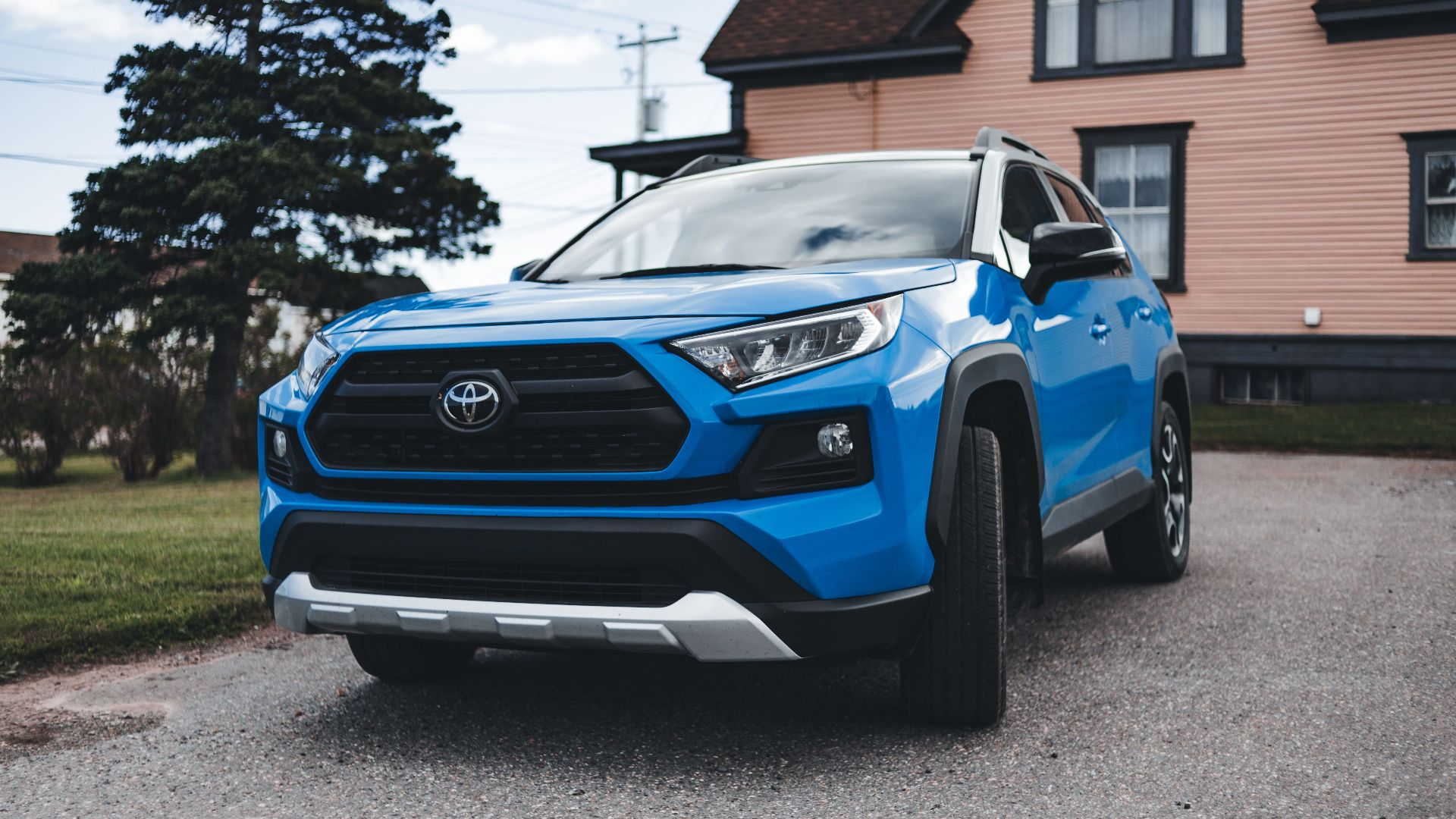 Blue Toyota SUV parked outside a house, showcasing modern automotive design in a suburban setting.