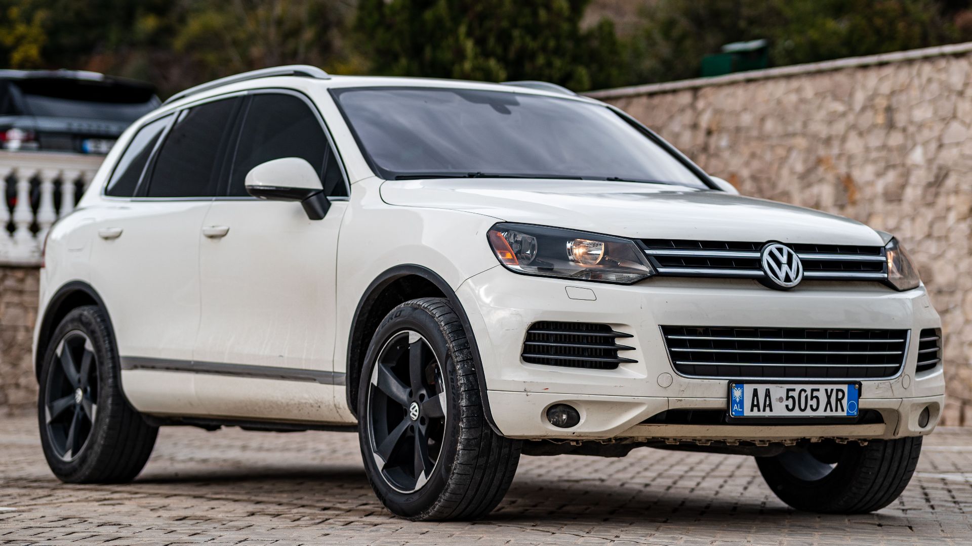 A sleek white Volkswagen Touareg SUV parked outdoors on a paved lot, showcasing modern design.