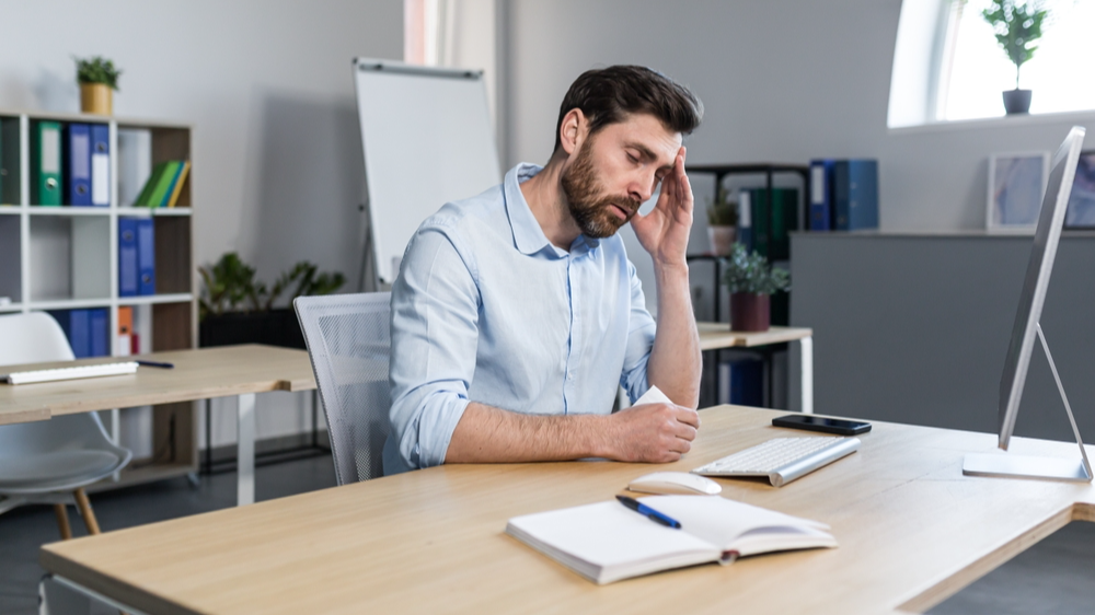 Bored Office worker sitting at a desk in the office not having something to do
