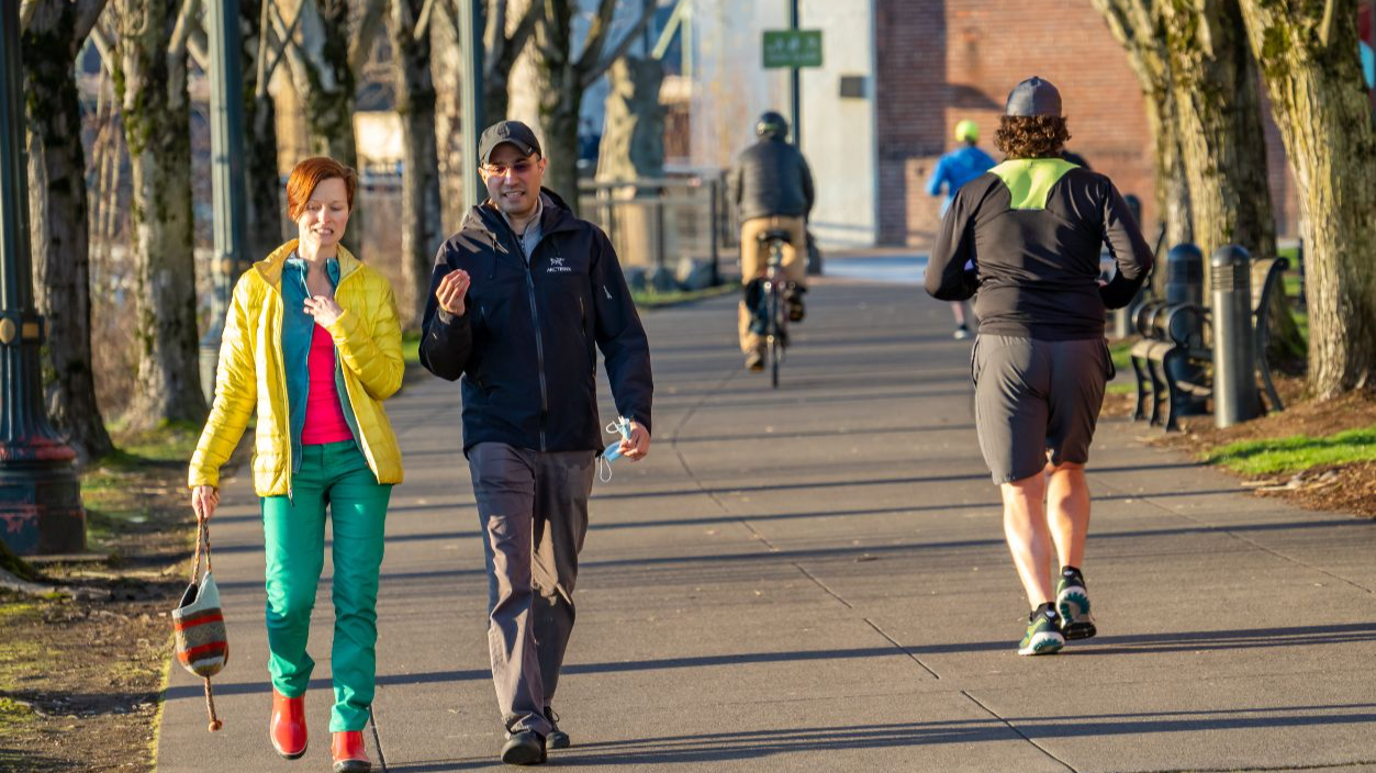 Shutterstock-1915608031, Portland, Oregon - 2-11-2021: a man and woman walking on the pedestrian bicycle path on the east shore of the Willamette River in Portland Oregon
