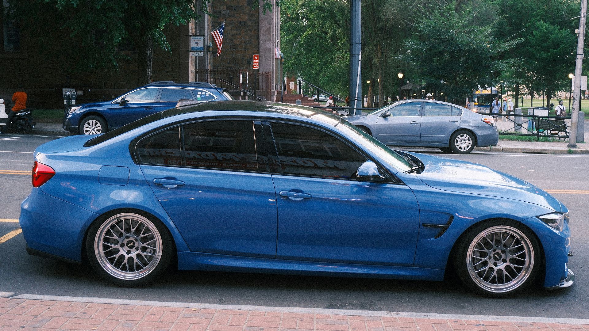 A sleek blue car parked on an urban street