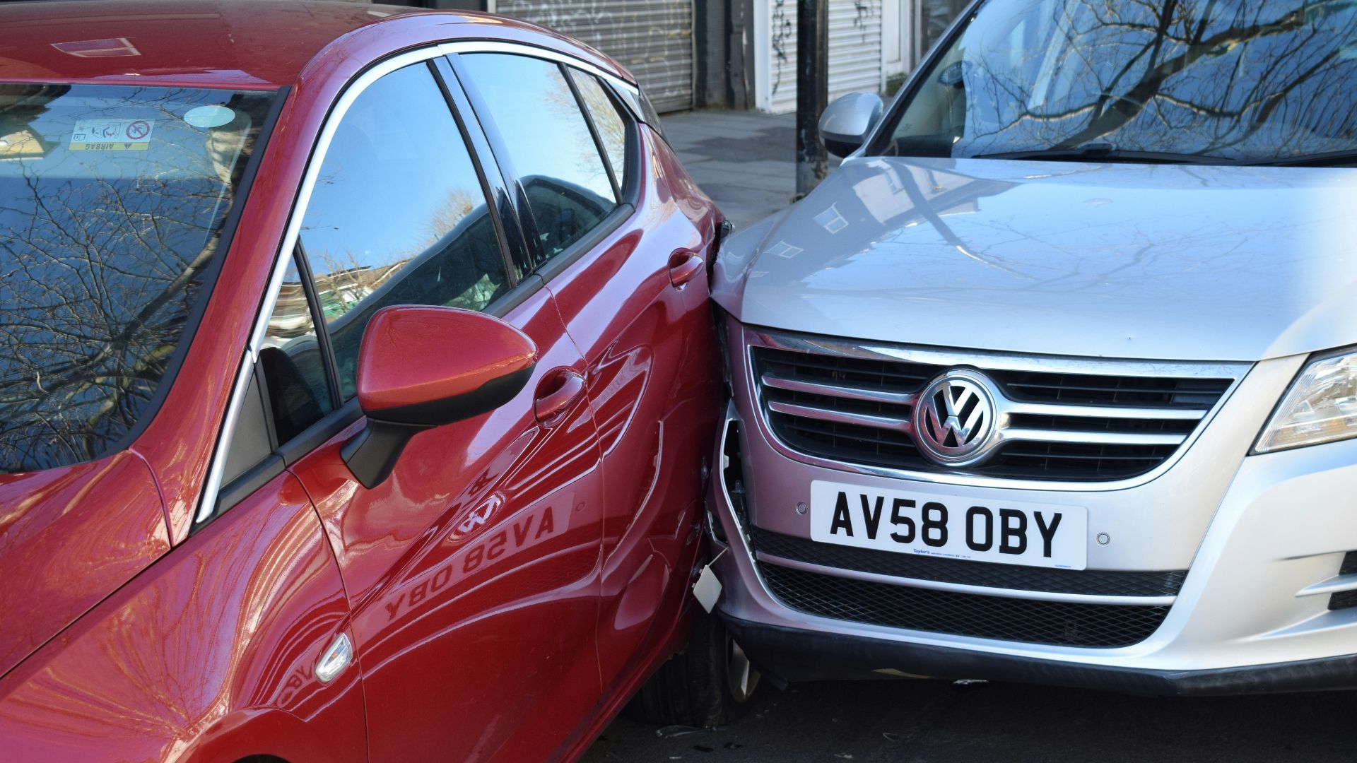 two cars parked next to each other in a parking lot