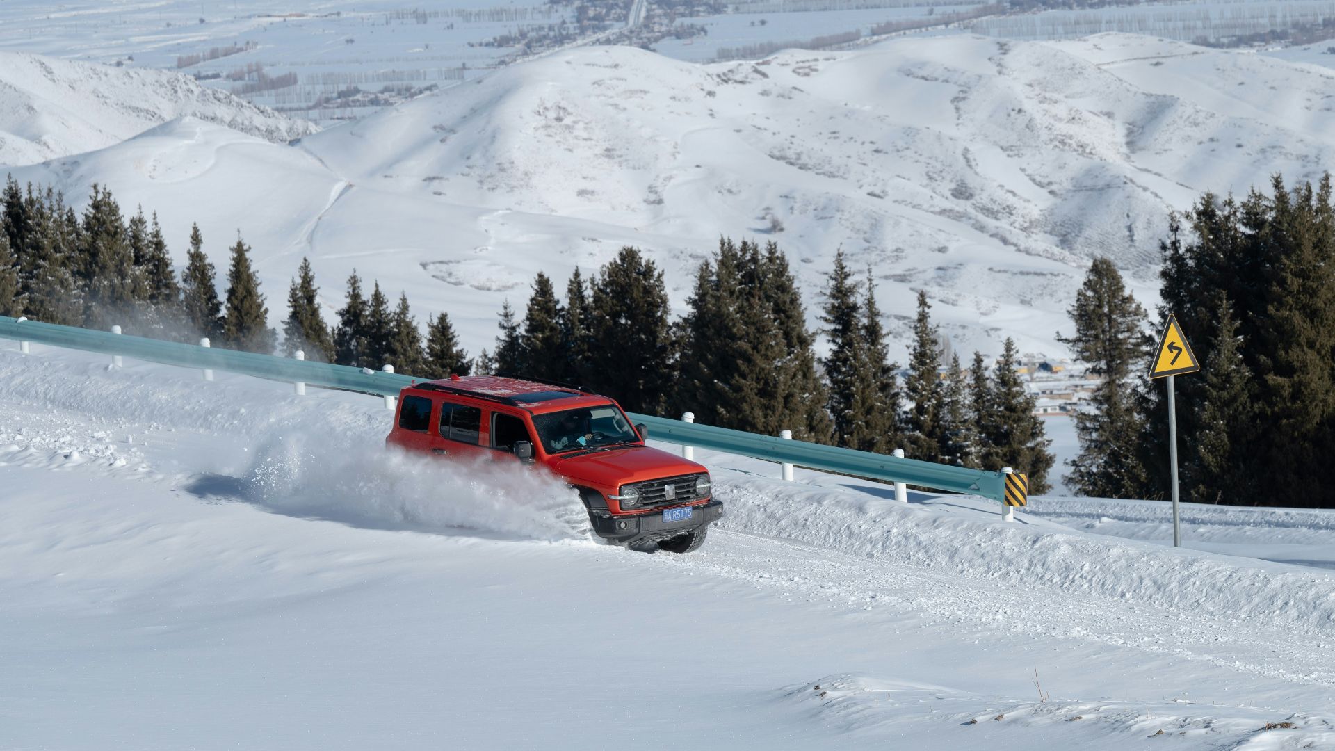 a red truck driving down a snow covered slope