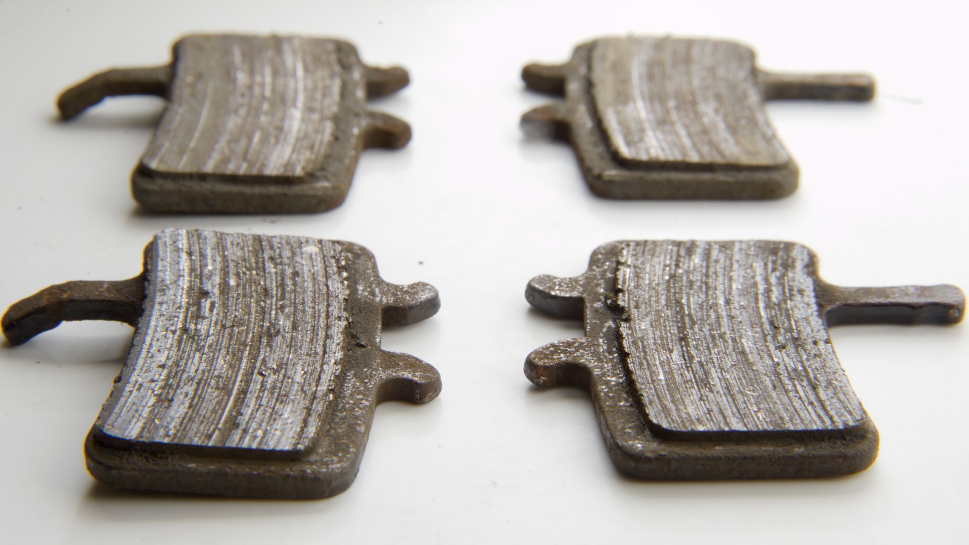 Worn metallic disc brake pads taken out of Avid BB7 disc brake calipers.  These pads began at about 3mm of pad material to about 1mm (as pictured).